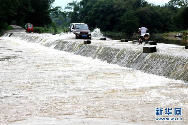 6月21日，车辆在广西罗城县龙岸镇龙平村积水路段前行。