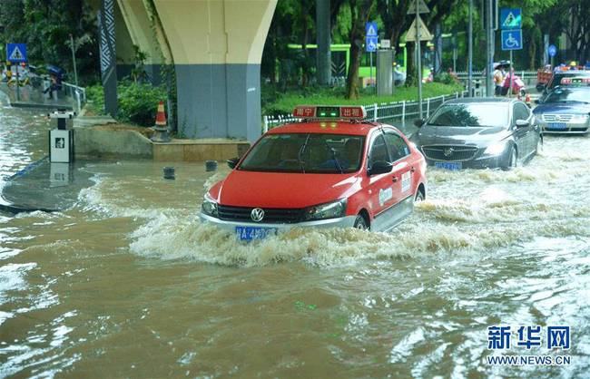 6月24日，车辆在广西南宁市城区一处积水路段涉水前行。