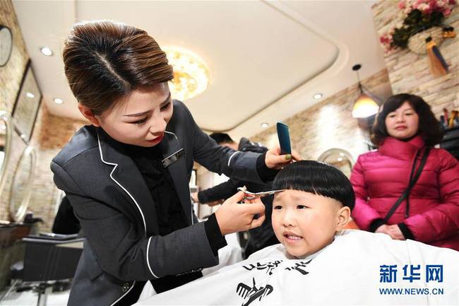 3月8日，在贵州贵阳市南明区沙南社区一家理发店，理发师在为一名小朋友“剃龙头”。