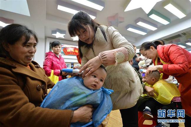 3月8日，在湖北襄阳市保康县一家婴幼儿理发店里，理发师为小朋友“剃龙头”。