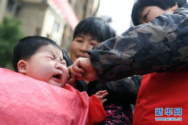 3月8日，在合肥市滨湖欣园社区，志愿者为陈言心小朋友“剃龙头”。 
