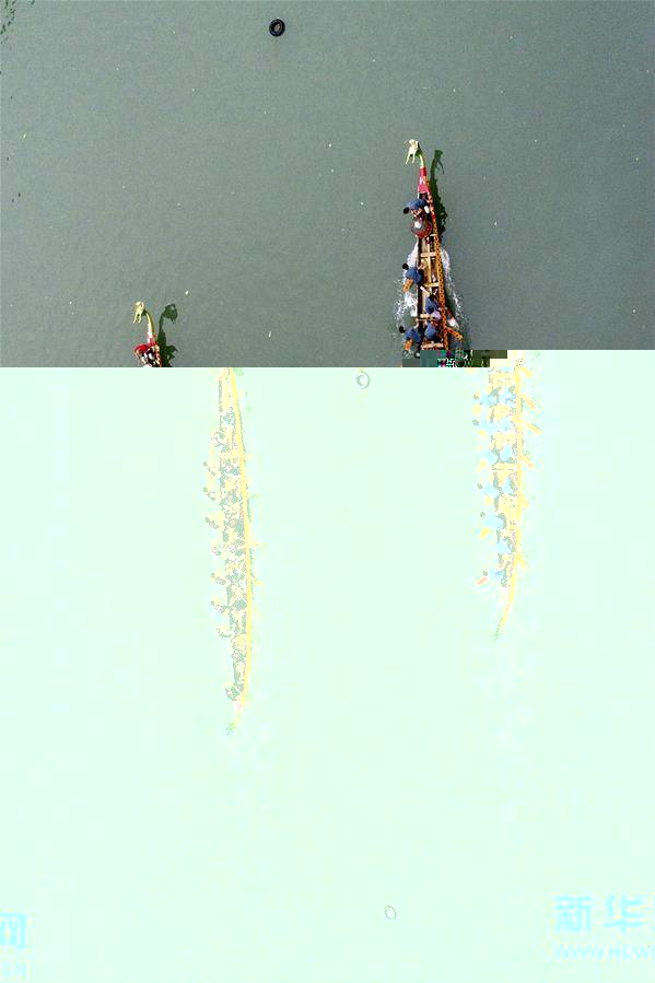 6月7日，在湖南省湘西土家族苗族自治州凤凰古城，人们在沱江上赛龙舟（无人机拍摄）。 新华社发（彭彪摄）