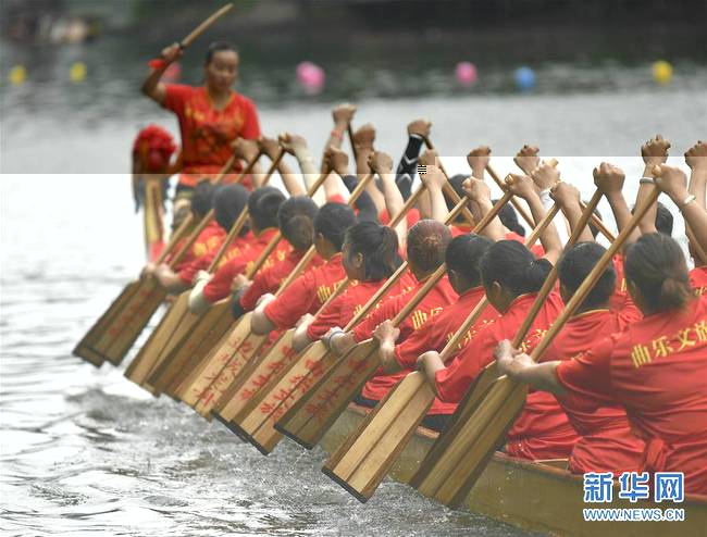 6月7日，在湖南花垣县边城镇清水江上，女子龙舟队员在比赛中竞逐。新华社发（龙恩泽摄）