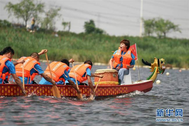 6月7日，在河北霸州胜芳古镇，人们在龙舟赛上比拼。新华社发（徐巍摄）
