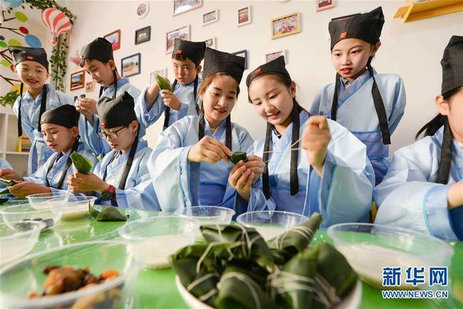 6月7日，在河北省邯郸市临漳县国学馆，孩子们和老师一起包粽子。新华社发（王洪超摄）