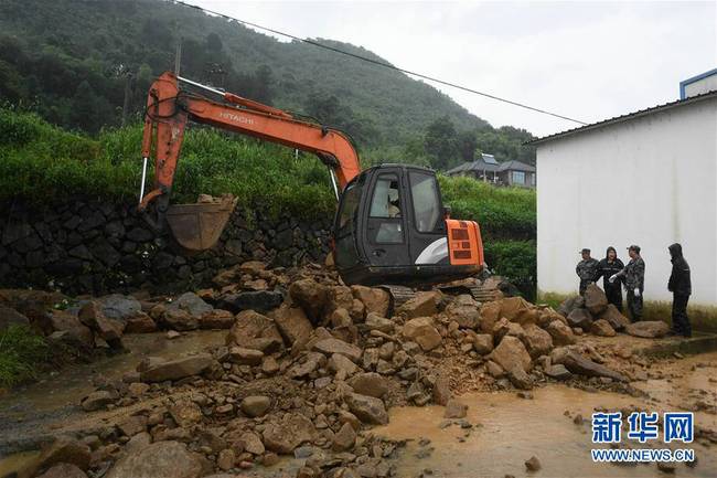 7月8日，应急抢险人员在桐庐县旧县街道紧急加固堤坝，排除一处管涌险情，以保护良田。新华社记者 黄宗治 摄