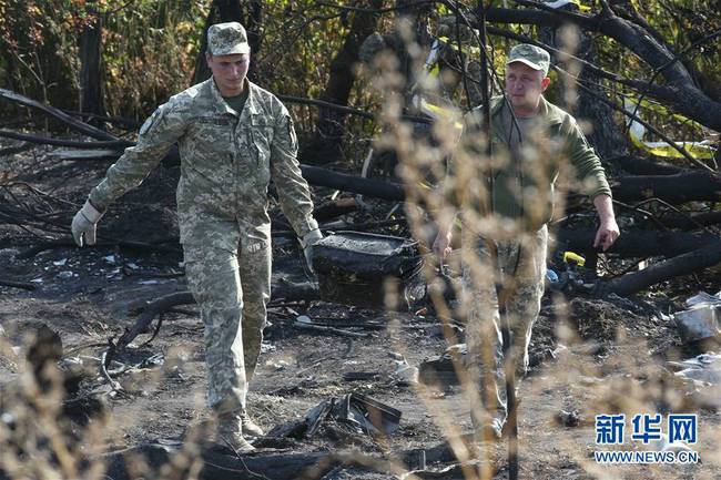 9月26日，工作人员在乌克兰哈尔科夫州的飞机坠毁现场清理残骸。谢尔盖·斯塔拉斯坚科摄