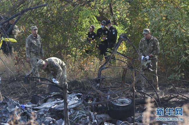 9月26日，工作人员在乌克兰哈尔科夫州的飞机坠毁现场清理残骸。 谢尔盖·斯塔拉斯坚科摄