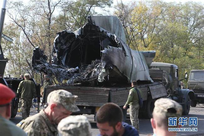 9月26日，工作人员在乌克兰哈尔科夫州的飞机坠毁现场将残骸装车。谢尔盖·斯塔拉斯坚科摄