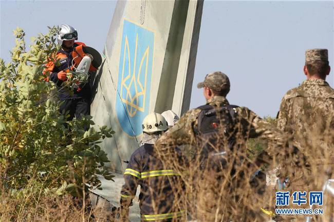 9月26日，工作人员在乌克兰哈尔科夫州的飞机坠毁现场切割飞机残骸。谢尔盖·斯塔拉斯坚科摄