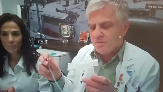 纳迪尔·阿尔伯在视频会议中展示“服药”设备。图片来源：会议视频截图