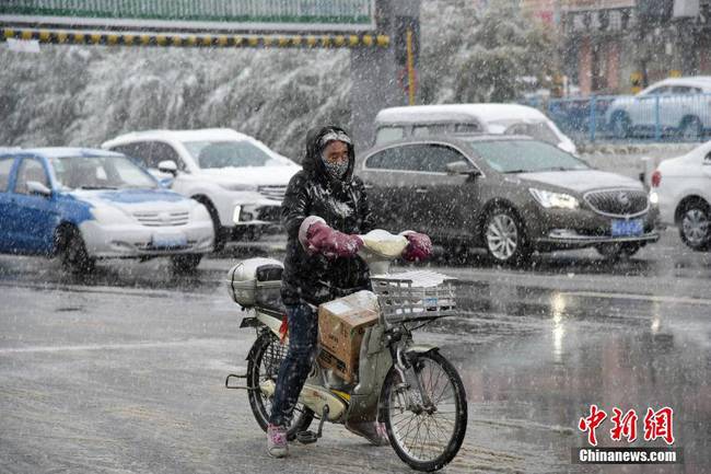 10月9日，内蒙古乌兰察布市迎来降雪，行人穿上了御寒的衣物。受冷空气影响，内蒙古中西部将先后出现雨转雨夹雪或雪的天气。 中新社发 唐豆子 摄